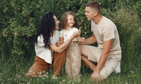 A joyful family enjoying time together in a lush green meadow, capturing love and bonding.